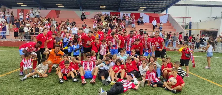 Los jugadores y la afición celebrando en el césped la buena temporada.