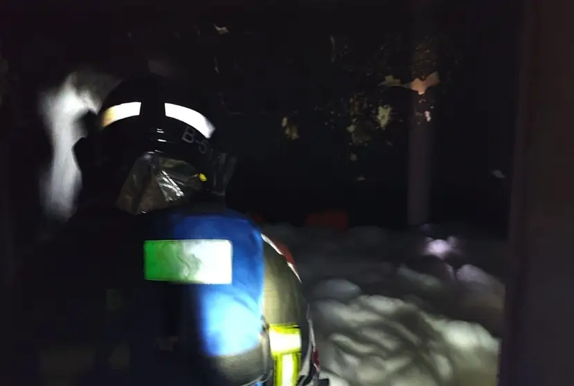 Bombero del Consorcio apagando el fuego localizado en el interior de la vivienda.