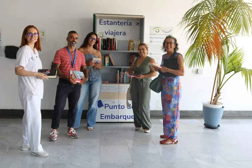 Personas junto a la Estantería viajera.
