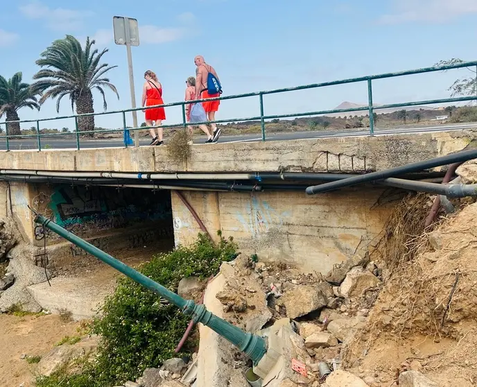 Turistas pasean este martes por el Barranco del Huroìn en Costa Teguise afectado por las lluvias del 12A,