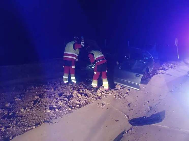 Bomberos junto al vehículo fuera de la calzada.