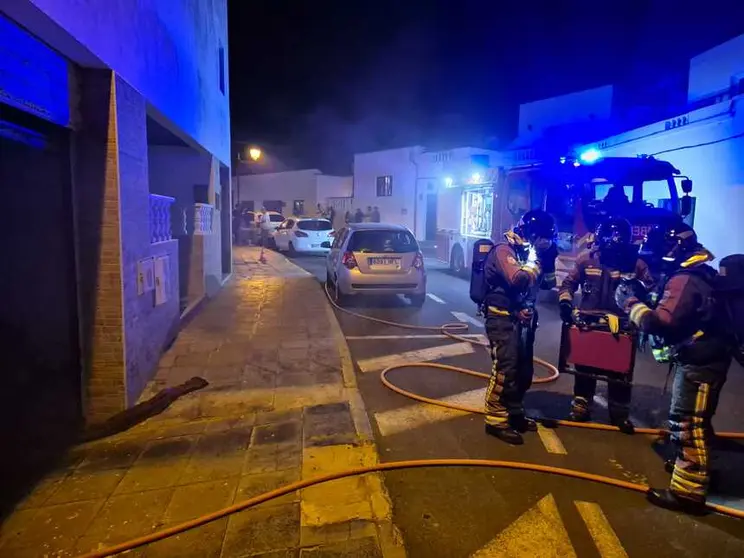 Bomberos junto al sótano afectado por el fuego.