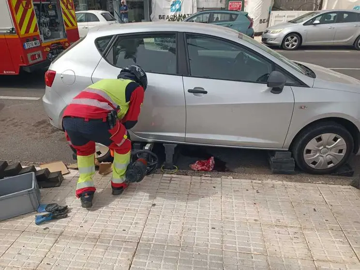 Bombero del Consorcio de Seguridad y Emergencias levantando el vehículo para auxiliar a la persona herida.