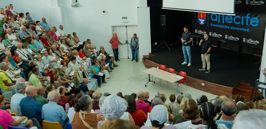 Rosmen Quevedo y Echedey Eugenio explicando a los mayores de Arrecife este lunes cómo van a ser los viajes.