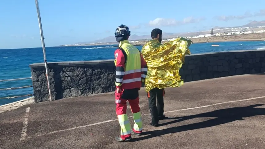 Imagen de uno de los bomberos que también acudió al rescate atendiendo a una de las personas que naufragó.