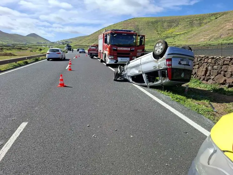 Cami&oacute;n de los bomberos junto al veh&iacute;culo volcado.