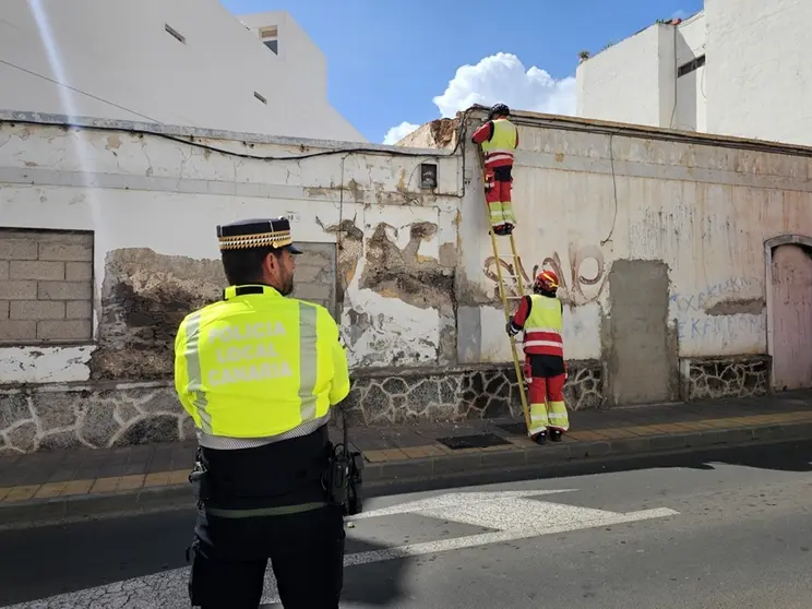 Agentes de la Polic&iacute;a Local de Arrecife en la calle Blas Cabrera Topham para evitar el tr&aacute;nsito mientras los bomberos retiran los cascotes de la fachada de ese inmueble