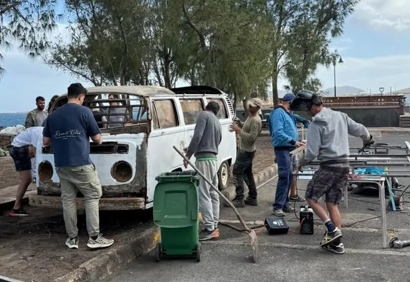 La gente trabajando a destajo en la reconstrucci&oacute;n de la furgoneta Volkswagen que hace las veces de bar en Arrieta