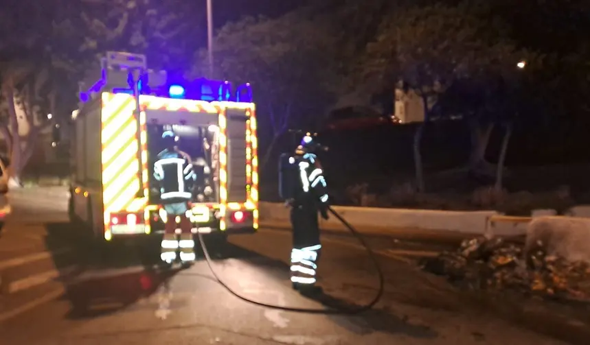 Bomberos del Consorcio de Seguridad y Emergencias apagando las llamas en un contenedor.