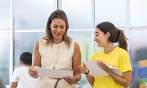 La concejal Maite Corujo con una de las alumnas viendo los trabajos.