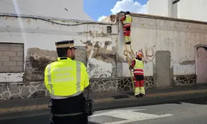 Agentes de la Polic&iacute;a Local de Arrecife en la calle Blas Cabrera Topham para evitar el tr&aacute;nsito mientras los bomberos retiran los cascotes de la fachada de ese inmueble