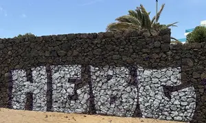 Imagen de una de las pintadas gigantes que han hecho en la piedra volc&aacute;nica de la playa