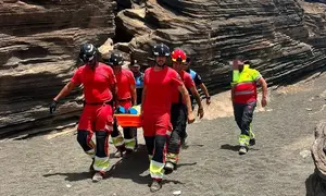 Momento en el que los bomberos y los polic&iacute;as locales trasladan a la persona herida.