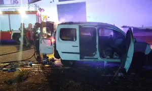 Bombero extinguiendo las llamas dentro del veh&iacute;culo.