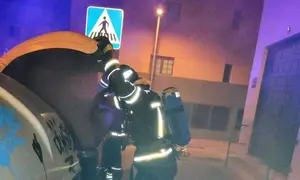 Bomberos del Consorcio de Seguridad y Emergencias sofocando el fuego dentro del contenedor.