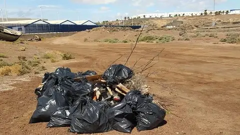 El Ayuntamiento de Arrecife limpia la playa de La Arena. Bolsas con los resiudos retirados