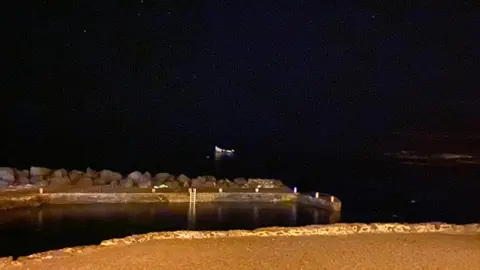 Imagen de la patera varada cerca del muelle de La Santa este lunes de madrugada.