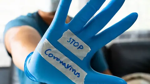 The glove-wearer has a message to stop the Coronavirus