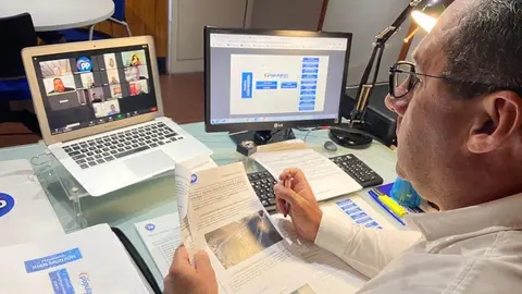 Juan Monzón en primer plano siguiendo la reunión desde su despacho por videollamada.