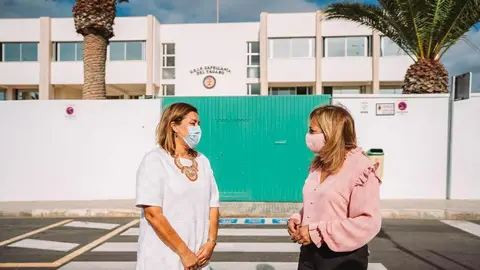 Adjudicadas las obras para la ampliaicón del ecocomedor del Capellanía. La alcaldesa y la concejal de Educación junto al colegio de Arrecife