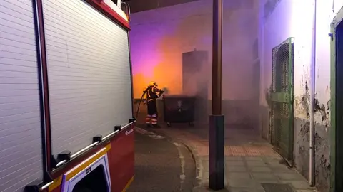 Instante en el que el bombero consiguió atajar el fuego del contenedor