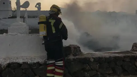 Imagen del momento en el que los bomberos controlaron el incendio en el solar de la vivienda afectada en La Villa.