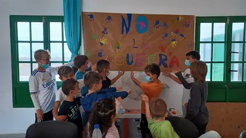 Niños de Tinajo junto al mural que realizaron contra la guerra de Ucrania.