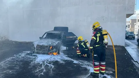 Los bomberos en el momento de apagar el fuego del veh&iacute;culo.
