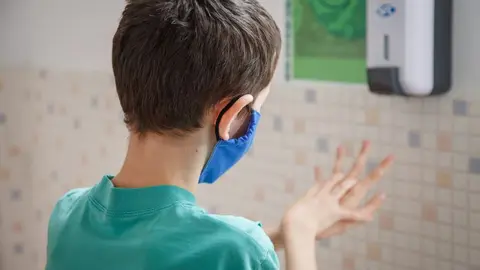 Niño con mascarilla dentro d eun centro educativo.