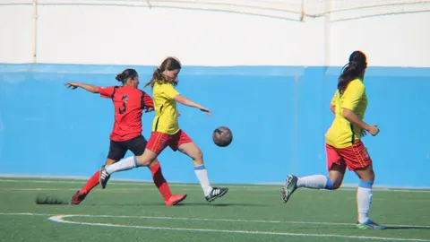Jugadora del Orientación Marítima intentando entorpecer el lanzamiento del FC Puerto del Carmen.
