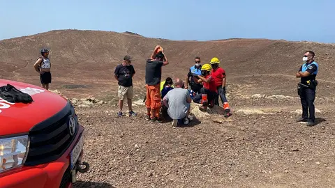 Componentes de los bomberos y la Policía Local auxiliando a la senderista.