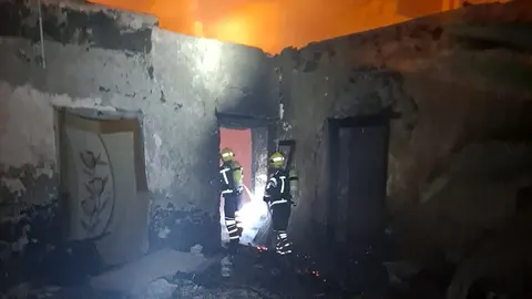 Bomberos durante su servicio en la vivienda abandonada.