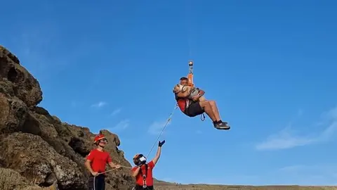Imagen del peligroso momento del traslado del senderista y su perro.