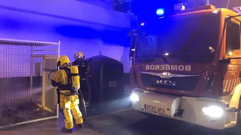 Los bomberos durante su actuación para sofocar el incendio del contenedor.