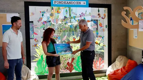 José Juan Cruz y Tomás silvera entregando  a la directora del IES Puerto del Carmen, Luz Divina Baena, un diploma en agradecimiento por su implicación en los proyectos.