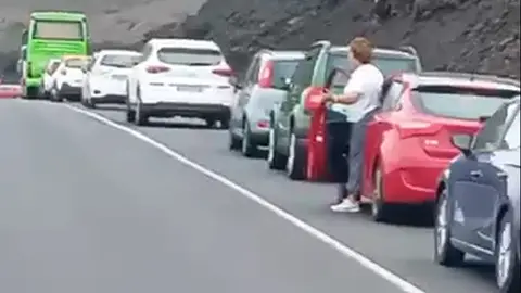 Imagen de la gente bajándose de los coches por la cola que hay. 