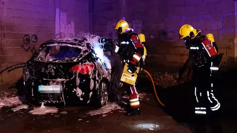 Imagen de los bomberos sofocando el fuego dentro del vehículo.
