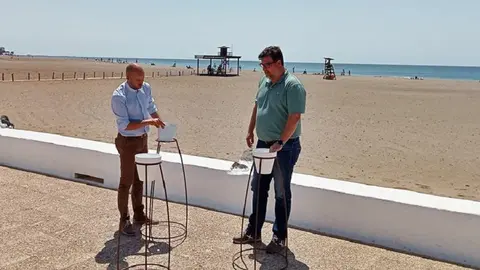 Imagen de Isidro Pérez y Raúl de León junto a los nuevos ceniceros de Playa Honda.