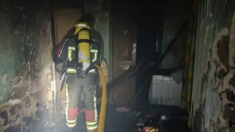 Imagen de los bomberos actuando en el incendio en la casa ocupada.