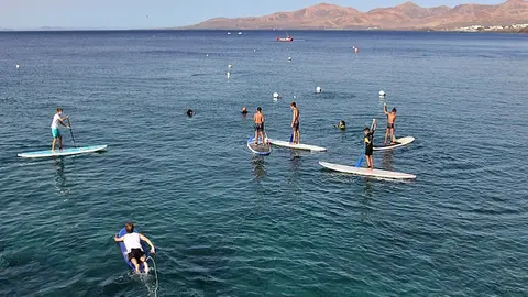 Imagen de gente realizando paddle surf en Puerto del Carmern.