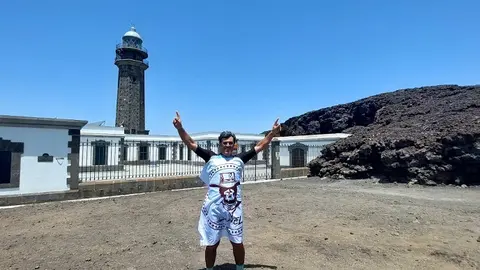 Imagen de Nacho Herrero en el meridiano cero de El Hierro con la bandera de la asociación DalecandELA.
