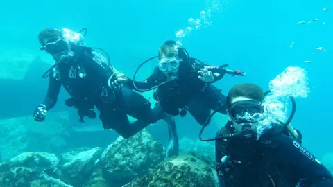 Imagen de tres de los jovenes participantes en la jornada de buceo.