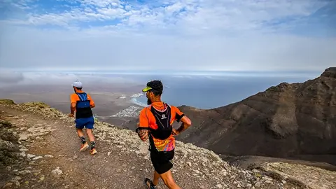 Imagen de dos participantes de la Famara Total 2022 durante el desarrollo de la prueba.