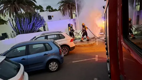 Imagen de los bomberos extinguiendo un fuego localizado en unos contenedores.