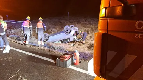 Imagen de los bomberos comprobando el estado del vehículo accidentado.