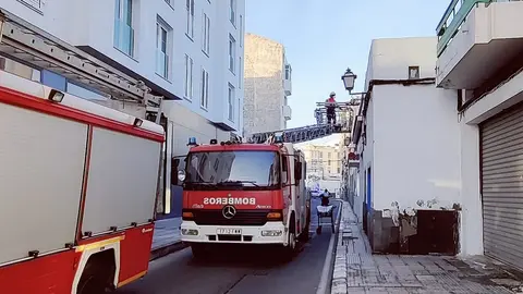 Imagen de los bomberos realizando la evacuación a través de la ventana del domicilio.