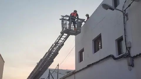 Imagen de los bomberos realizando la extracción del afectado con la autoescala..