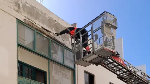 Imagen de los bomberos comprobando el estado de la fachada dañada.