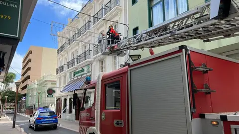Imagen de los bomberos recogiendo uno de los cables caídos en la calle Fajardo