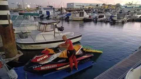 Imagen de uno de los bomberos que actuó este lunes y la moto con la que rescató al windsurfista
